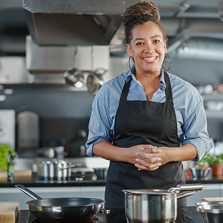 Chef cuisinier dans sa cuisine qui regarde la caméra